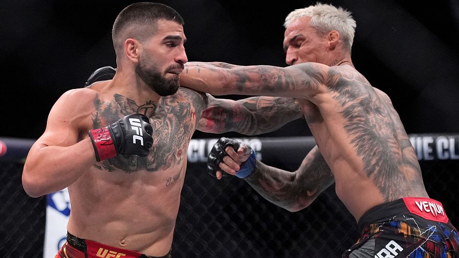 Ilia Topuria, a la izquierda, golpea a Charles Oliveira en una pelea por el título de peso ligero en UFC 317