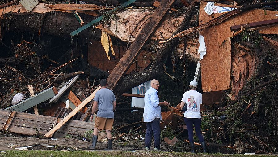 Personas observan los escombros en las orillas del río Guadalupe después de que una inundación repentina arrasara la zona el sábado 5 de julio de 2025, en Hunt, Texas.