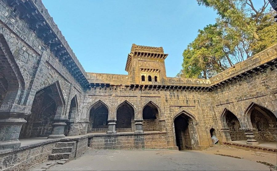 Patio interior de piedra con arcos ojivales y torre central en el Fuerte de Panhala.  Arquitectura que recuerda al sultanato de Bahamani. Posible toma aérea.