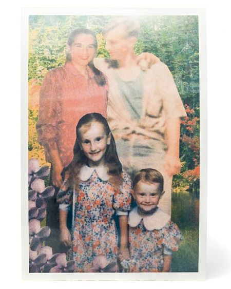 Foto familiar vintage: padres e hijas, ella con blusa rosa, él con camisa beige, las niñas con vestidos florales. Fondo con vegetación.