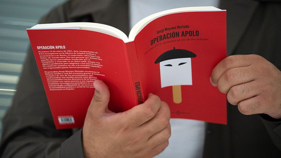 Libro abierto con portada roja titulado 