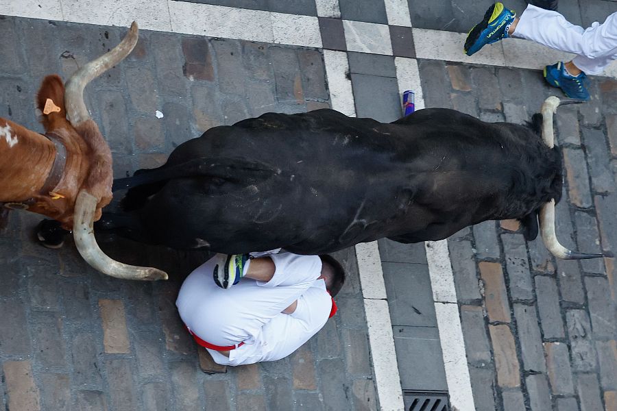 San Fermín 2025: un mozo se protege ante el paso de la veloz manada de Victoriano del Río