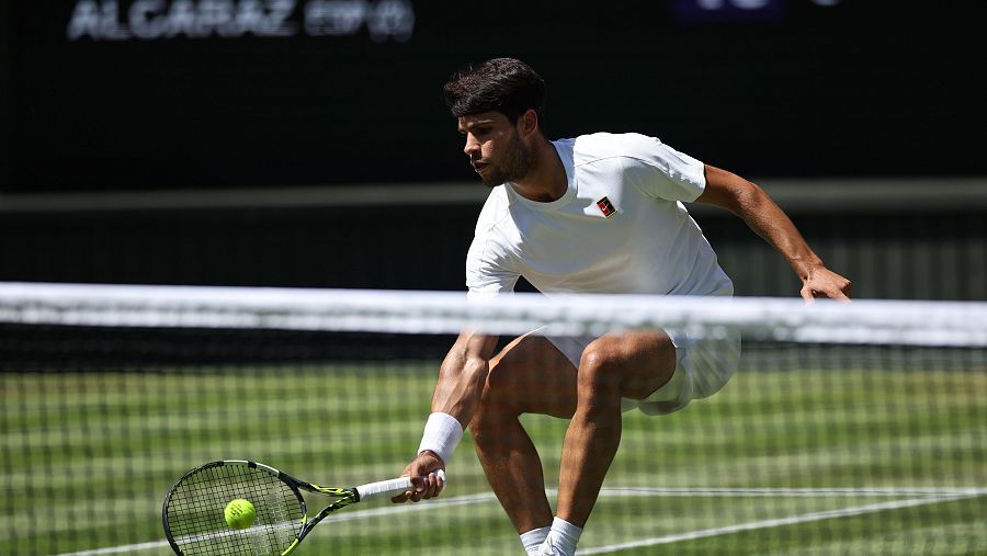 Carlos Alcaraz, flexiona el cuerpo para golpear una pelota en el partido de semifinales de Wimbledon ante Taylor Fritz