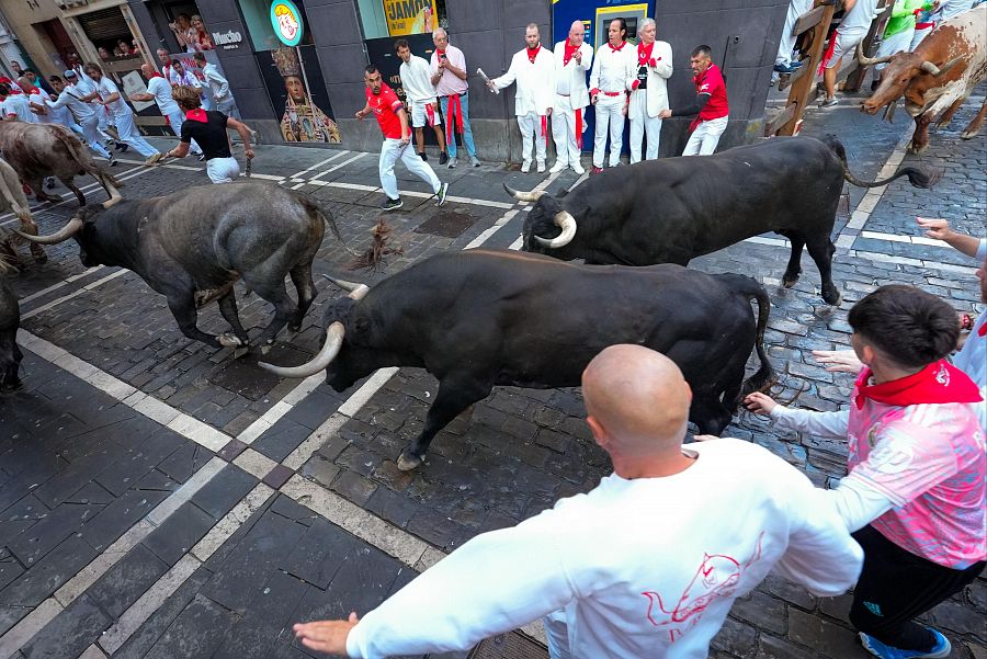 San Fermín 2025: los mozos son perseguidos por toros de la ganadería sevillana de Miura en el tramo de Mercaderes