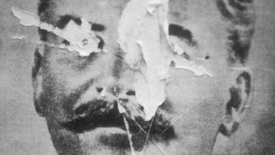 Póster desgastado y roto de Stalin en blanco y negro.  Se aprecian sus rasgos faciales, especialmente el bigote.  El deterioro sugiere vandalismo o rechazo.