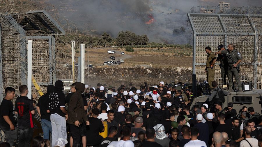 Personas drusas procedentes del Golán y Galilea cruzan la zona de seguridad para entrar en Siria, cerca de la aldea de Majdal Shams, en los Altos del Golán