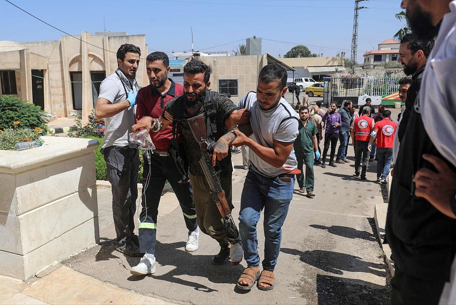 Un combatiente de una tribu beduina siria es ayudado a llegar a un hospital en Izra, en la provincia meridional siria de Daraa