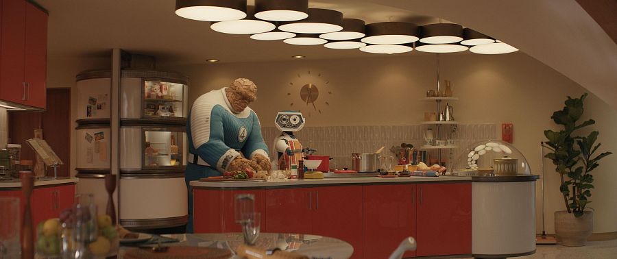 La Cosa y H.E.R.B.I.E. en una cocina retro-futurista; La Cosa prepara comida, asistido por el robot.