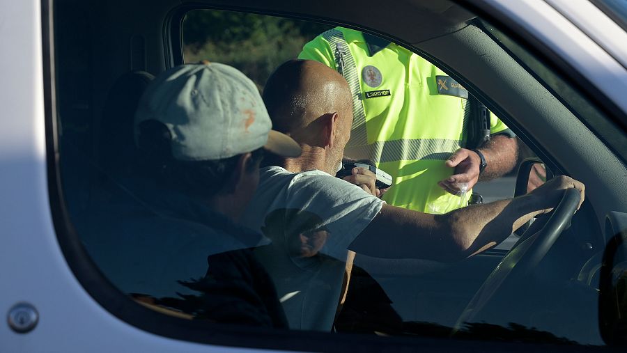 Un conductor hace el test de alcoholemia observado por un agente de la Guardia Civil