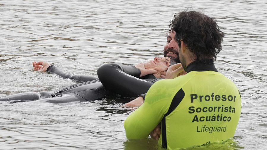 Rescate acuático simulado: socorrista con traje amarillo asiste a una persona en el agua.  Se enfatiza la prevención como parte principal del trabajo.
