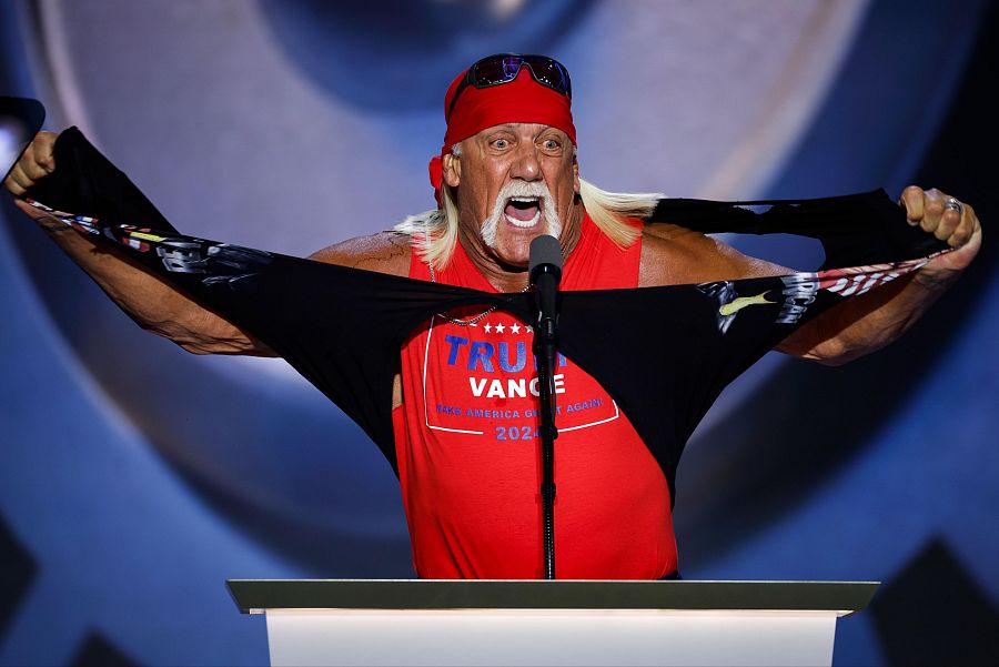 Hulk Hogan, con bandana roja y gafas, rasga una camiseta para mostrar una con 