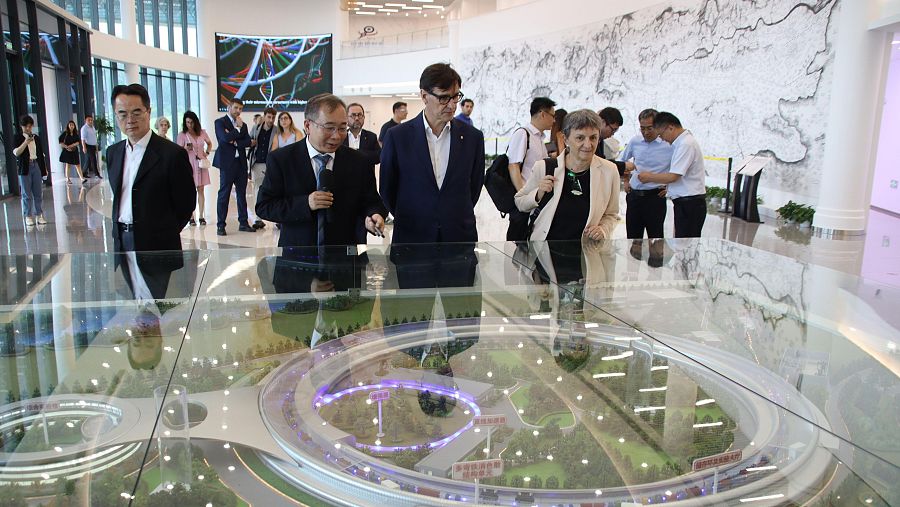 El president de la Generalitat, Salvador Illa, i la directora del Sincrotró ALBA, Caterina Biscari, observant una maqueta del sincrotró de Pequín.