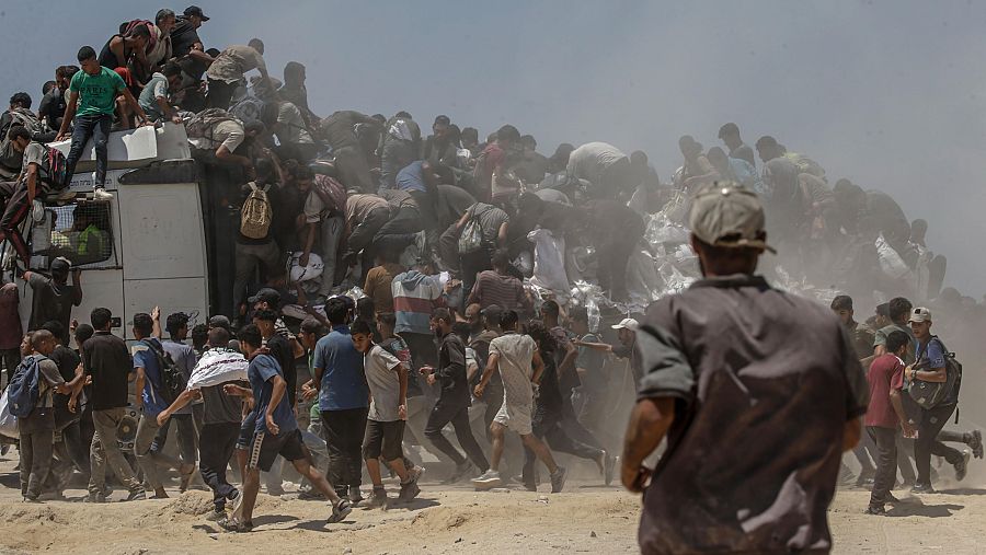 Gazatíes intentan hacerse con sacos de harina de un camión de ayuda humanitaria en Zikim, al norte de la Franja de Gaza