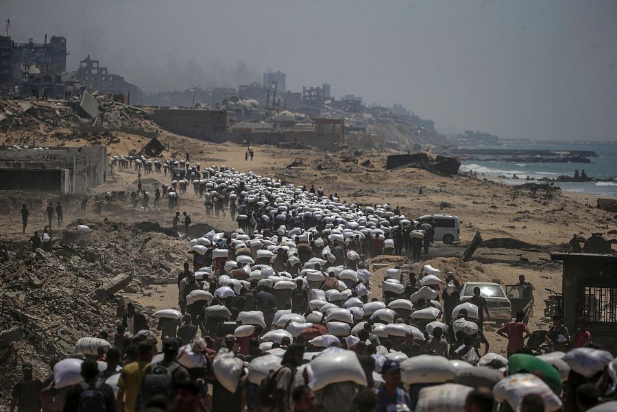 La población palestina se moviliza para recoger los sacos de harina cerca de un punto de distribución de alimentos en Zikim, al norte de la Franja de Gaza