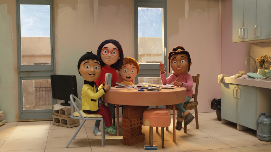 Cuatro niños en una cocina en reformas, alrededor de una mesa con libros y cuadernos; uno usa una tablet, otro lee, uno está sorprendido y otro escribe.  Detalles cotidianos presentes.