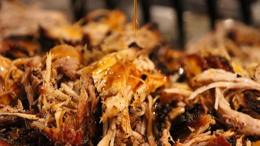 Carne de cerdo desmenuzada con tonos marrones, desde claro a oscuro, bañada en un líquido espeso y brillante.  Aspecto jugoso y tierno.