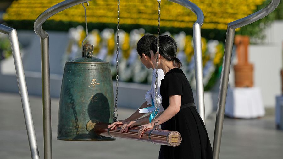 Dos personas tocan una campana durante la ceremonia para conmemorar el 80 aniversario del bombardeo de Hiroshima