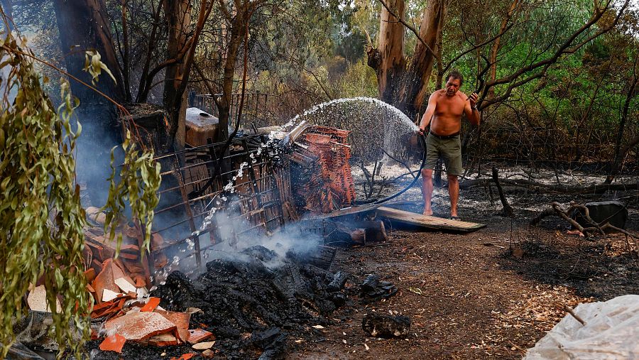 Una persona intenta apagar unas llamas en el incendio del paraje La Peña, Tarifa