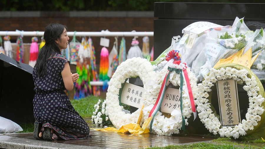 Una mujer ofrece una oración bajo la lluvia en el Parque del Hipocentro de la Bomba Atómica