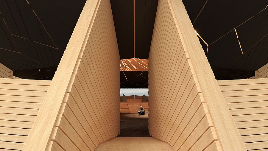 Pasillo interior de madera con listones horizontales, iluminación tenue y una persona sentada al fondo en un espacio más amplio.