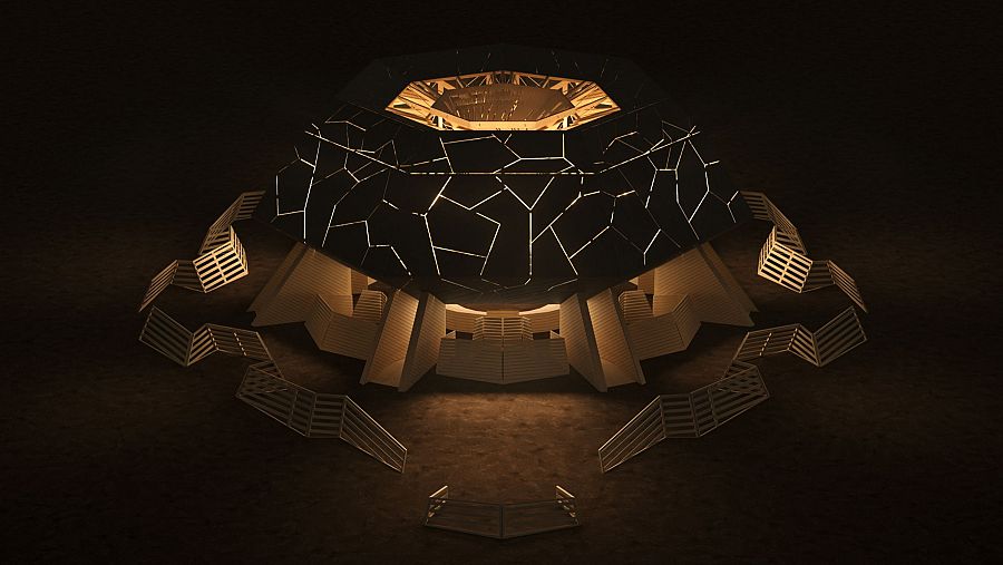 Templo iluminado de noche con cúpula facetada, base poligonal clara y barreras de madera.  Escaleras conducen a la entrada.