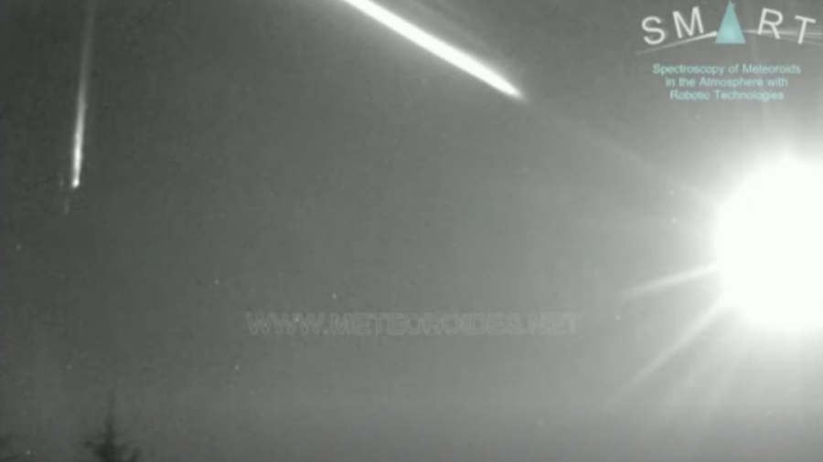 Cielo nocturno con dos meteoros, uno más largo que otro.  Se observa texto 