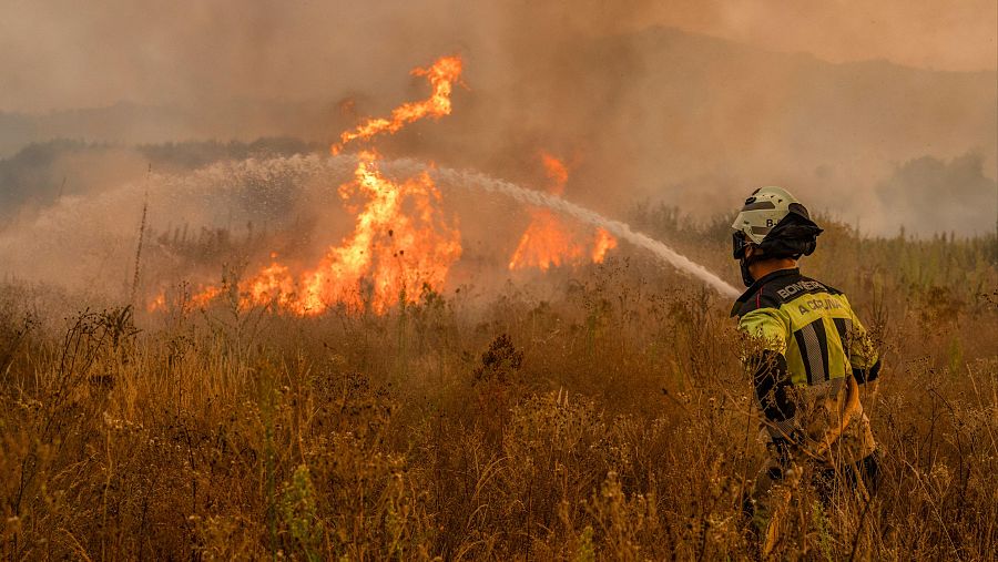 Un bombero trabaja en las labores de extinción del incendio forestal que permanece activo este martes en Monterrei (Ourense)