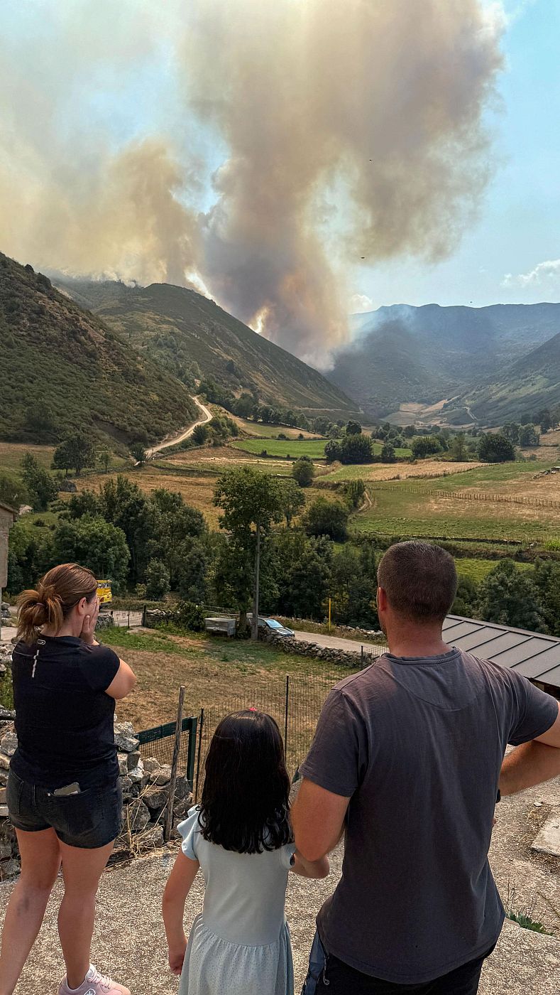 Una familia observa el fuego cerca del pueblo de Genestoso (Cangas del Narcea).