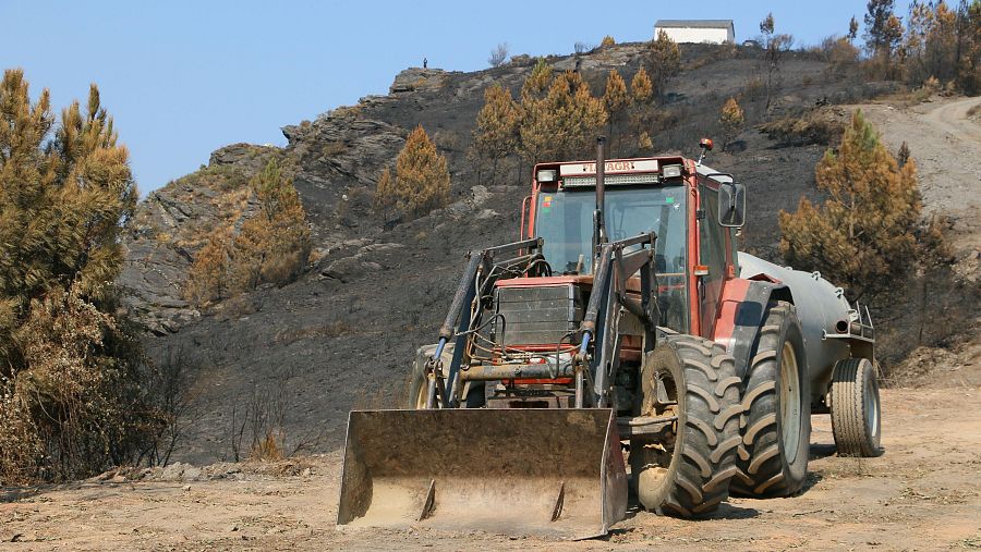 Un tractor con cisterna en una de las zonas arrasadas por el incendio