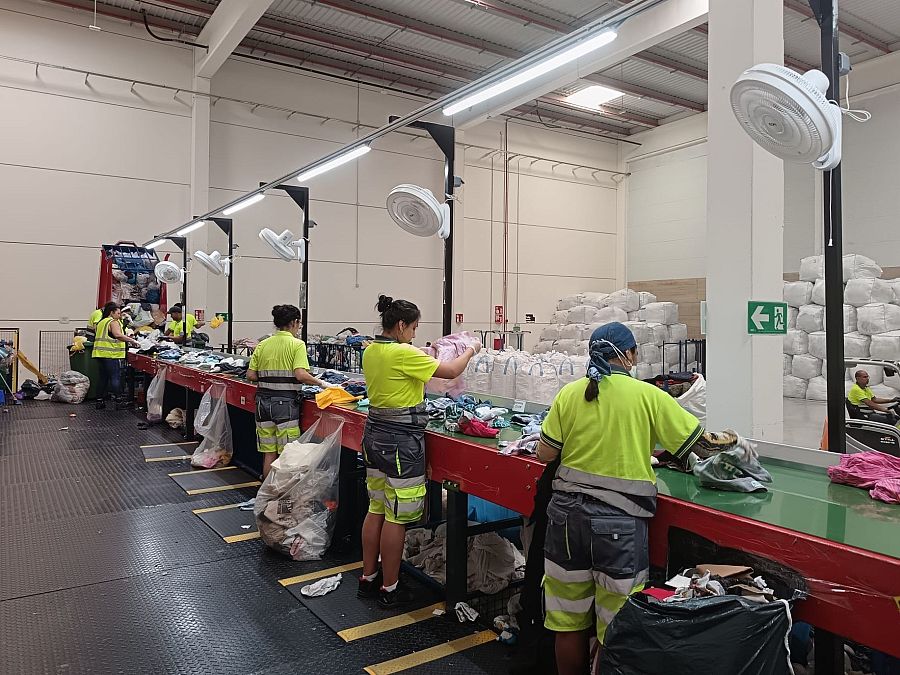 Linea de selección de ropa en una planta de reciclado de Moda Re-