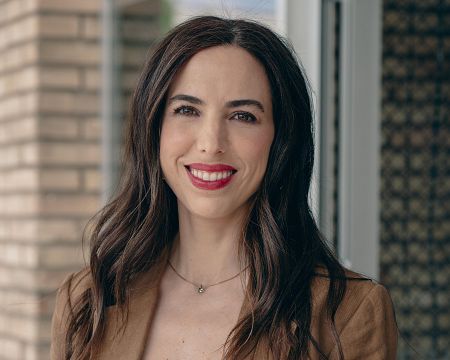 Mujer con cabello oscuro y chaqueta marrón sonriendo.  Texto superpuesto indica 'COM sin gluten SONIA' y 'Comercial'.