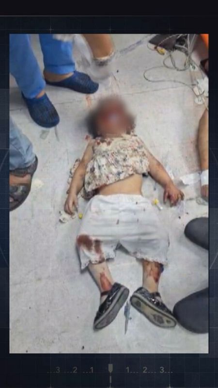 Niña herida tendida en el suelo, con manchas de sangre en la ropa. Personal médico a su alrededor.  Contexto de emergencia médica.