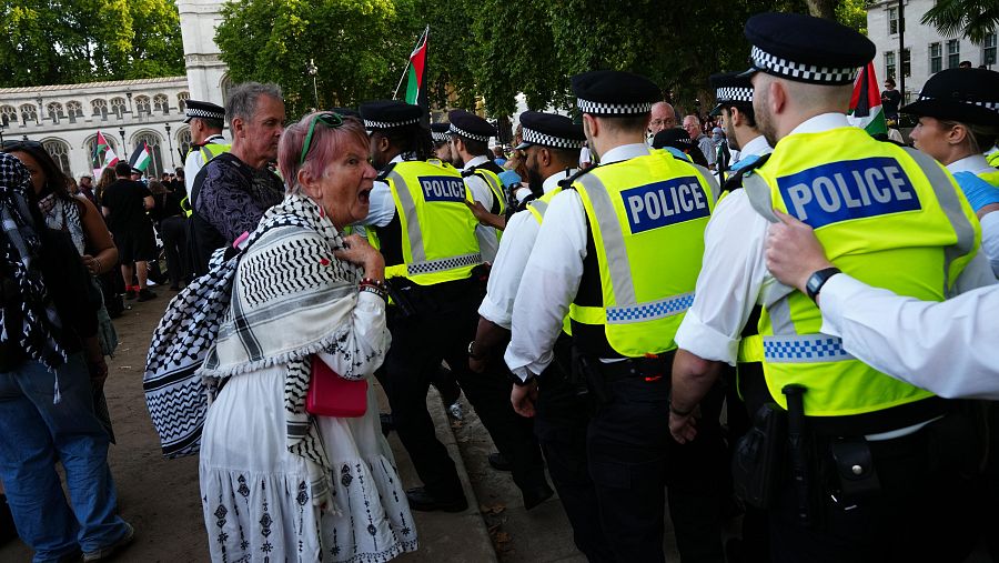 Una manifestante grita a los policías mientras participa en una protesta “Levanten la prohibición de Palestine Action” organizada por Defend Our Juries en la plaza del Parlamento de Londres.