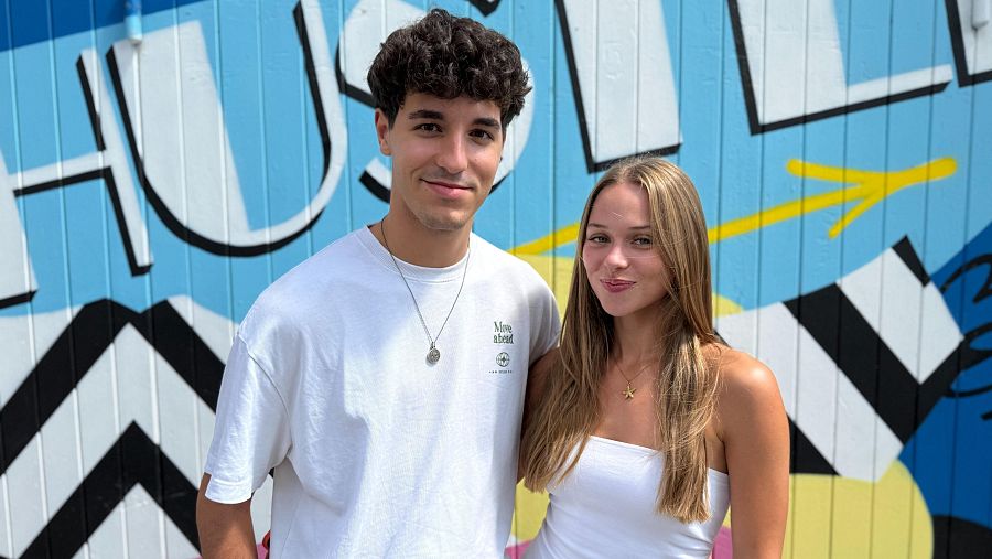Jóvenes posando ante mural geométrico con la palabra 