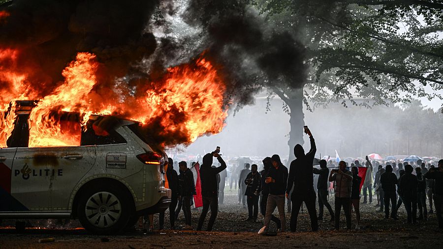 Imagen del vehículo incendiado durante los disturbios