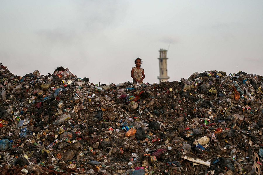 Una niña observa desde lo alto de un vertedero de basura en el campo de refugiados de Bureij