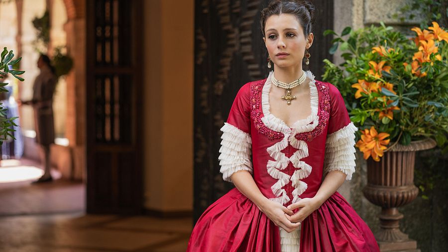 Bárbara luce un vestido de satén de seda color grosella decorado con tul de seda fruncido en blanco roto