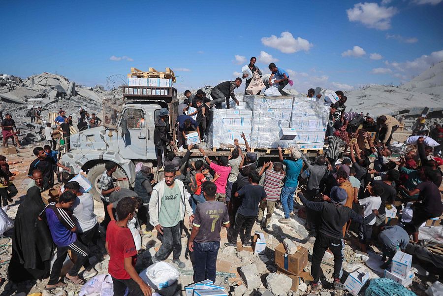 Palestinos reciben paquetes de alimentos después de que los camiones de ayuda entraran por Jan Yunis, al sur de la Franja de Gaza.