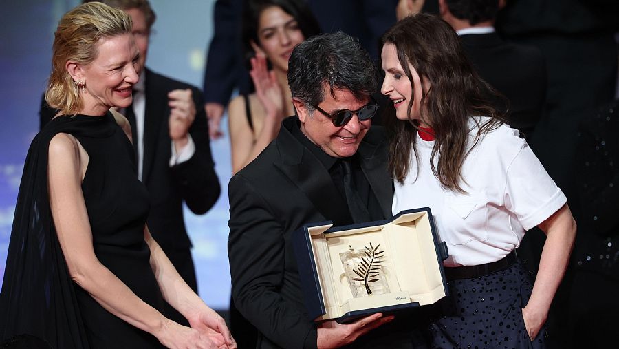 Jafar Panahi, al recibir la Palma de Oro de Cannes, entre Cate Blanchett y Juliette Binoche.