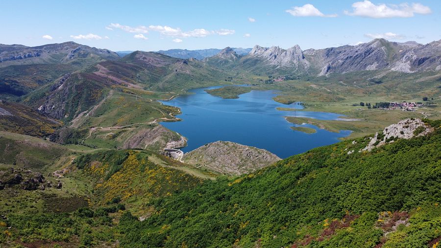 Vista aérea del embalse de Arbás rodeado de montañas y vegetación en la Reserva de la Biosfera del Alto Bernesga, León.