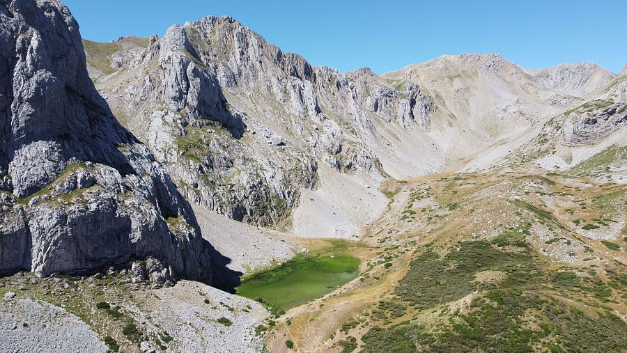 Vista aérea de la laguna de Las Verdes rodeada de montañas rocosas en la comarca de Babia, León.