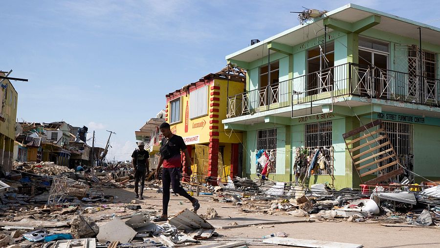 Personas caminan por una calle destruida en Black River (Jamaica).
