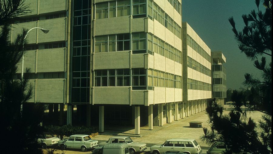 Fotografía de la Casa de la Radio en Prado del Rey, mostrando un edificio moderno con paneles y ventanas, y coches antiguos en primer plano, tomada en 1975.