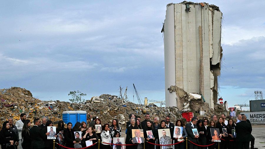 Familiares de las víctimas de la explosión en Beirut esperan al papa frente a los restos de uno de los silos en el puerto de la capital libanesa.