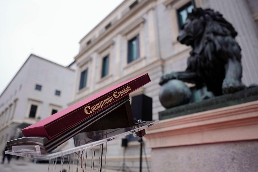 Ejemplar de la Constitución Española colocado ante los leones que custodian la entrada principal del Congreso de los Diputados