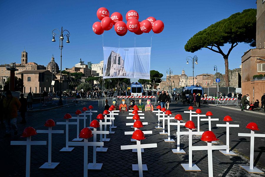 Cruces blancas con cascos rojos recuerda las muertes laborales en la avenida del Foro Imperial de Roma durante la jornada nacional de huelga