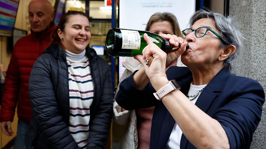 Una mujer celebra el segundo premio en la administración de loterías del número 10 de la calle Barquillo, en Madrid