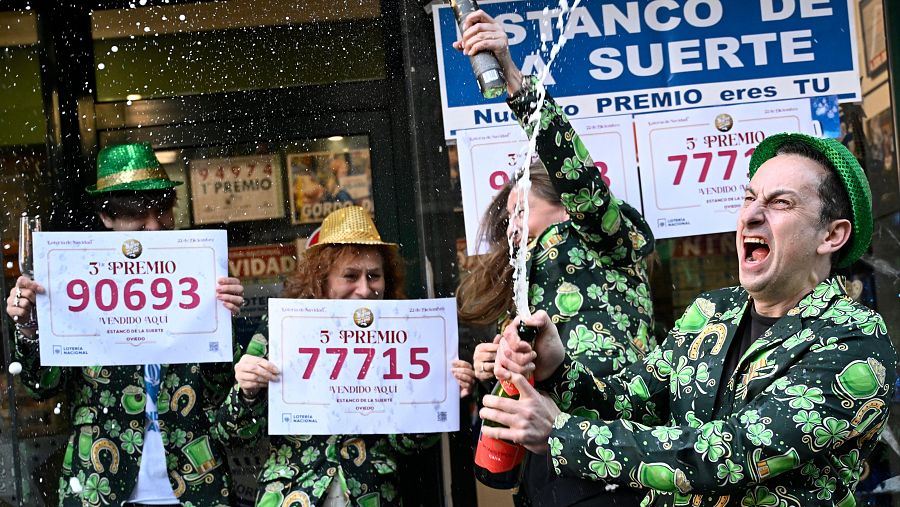 Empleados de una administración de lotería de Oviedo celebran tras haber vendido décimos del 90693, el tercer premio, y del 77715, uno de los quintos premios.