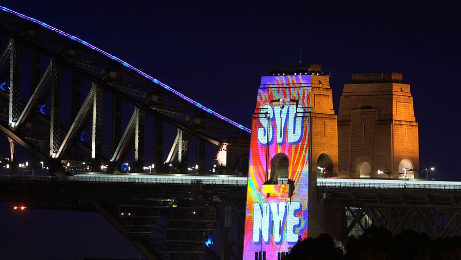 Un letrero multicolor se proyecta sobre el puente de la bahía de Sídney durante las celebraciones de Año Nuevo en Australia.