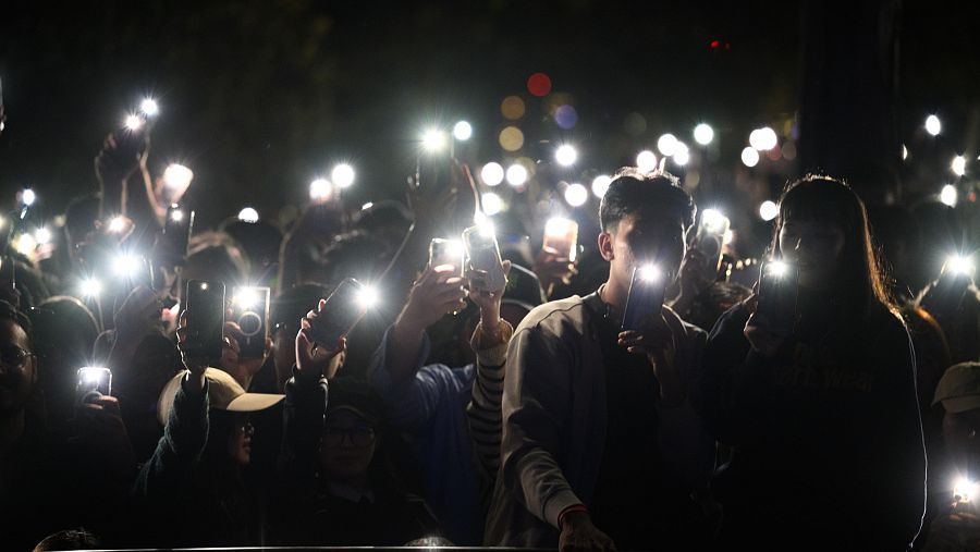 Los espectadores iluminan con sus teléfonos móviles durante las celebraciones de Nochevieja en Sídney.